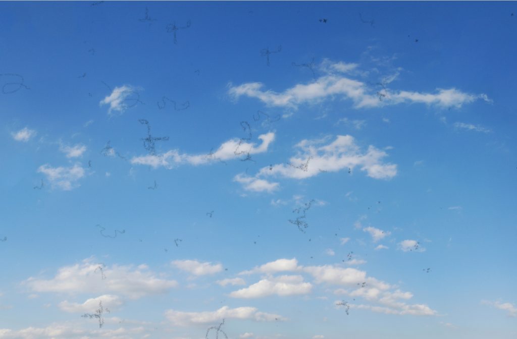 A blue sky with clouds with scattered lines and dots all over to simulate what it's like to have eye floaters.