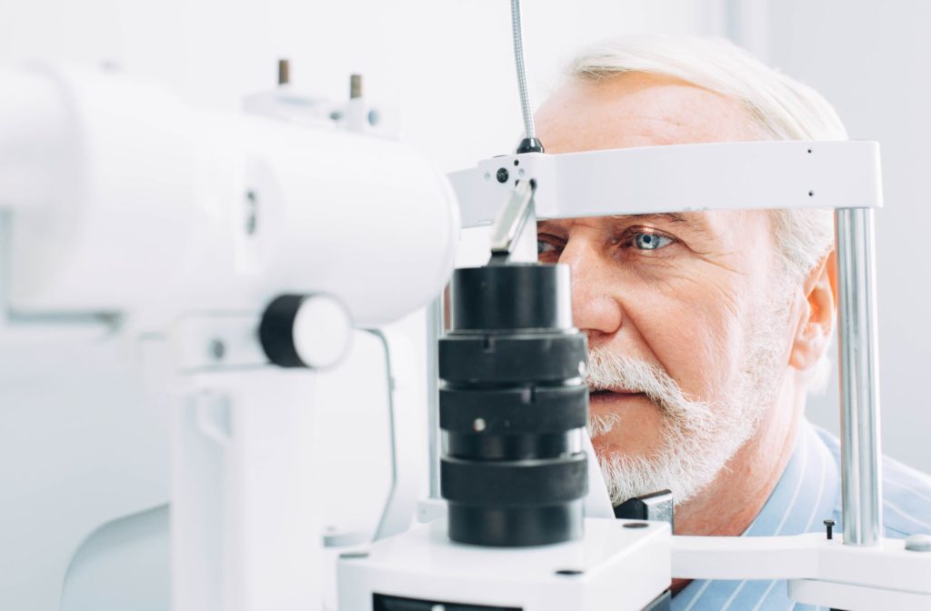 An older man getting his eyes examined for any eye conditions at the optometrist