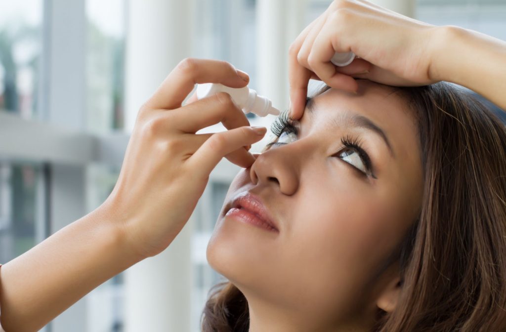 A young girl using an eye lubricant to treat dry eye