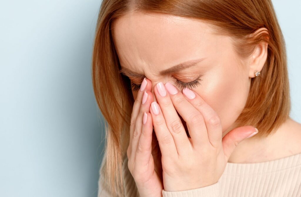 A woman rubbing her dry and itchy eyelids