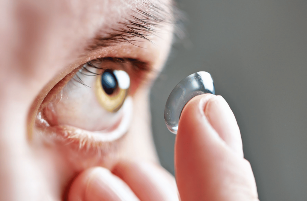 A close-up image of a woman carefully inserting a contact lens.